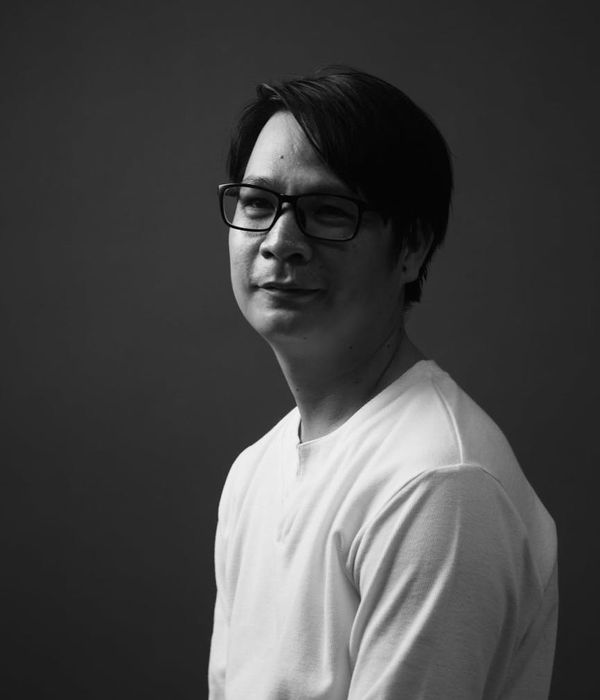 Man in a calm, focused pose in a minimalist room with soft light.